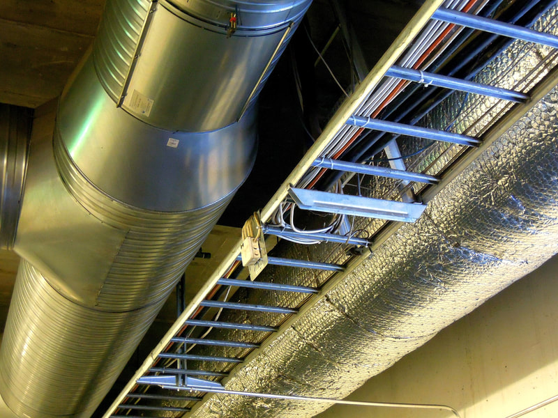 Ventilation pipes and wiring hung from ceiling.