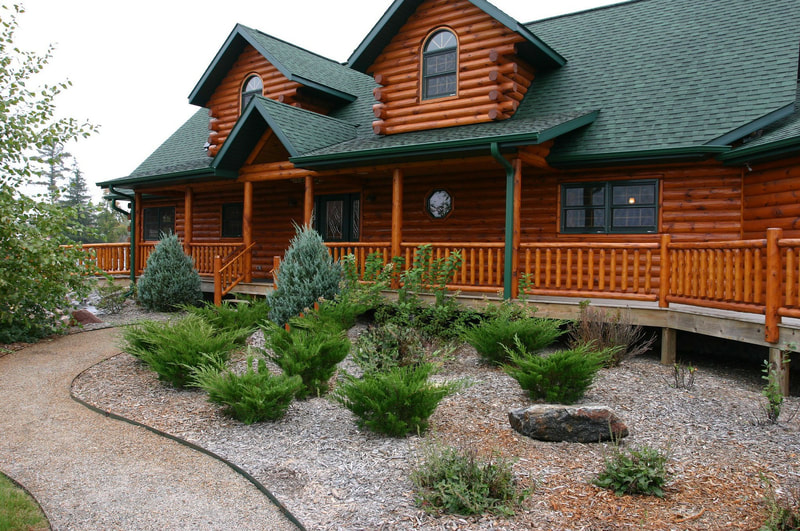 Front balcony and landscaping in front of a large log home
